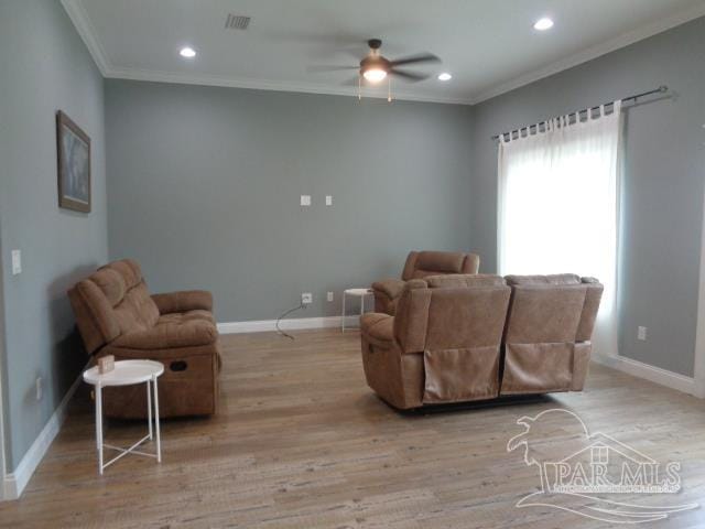 living room with light hardwood / wood-style floors, crown molding, and ceiling fan