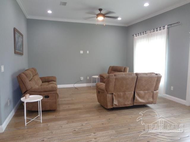 living room featuring light hardwood / wood-style floors, ornamental molding, and ceiling fan