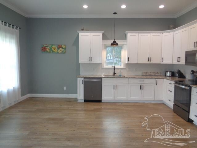 kitchen with pendant lighting, white cabinetry, stainless steel appliances, and light wood-type flooring