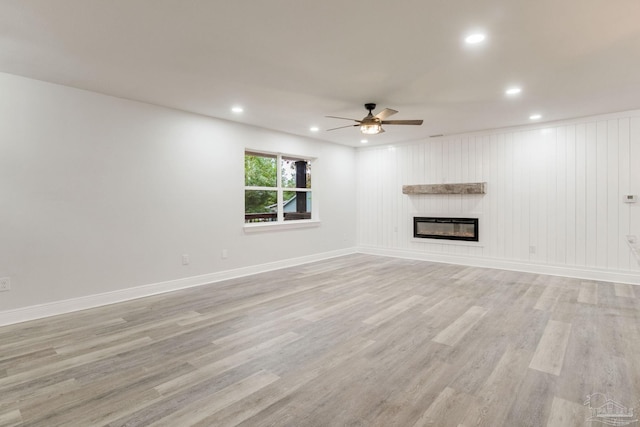 unfurnished living room with light wood-type flooring and ceiling fan