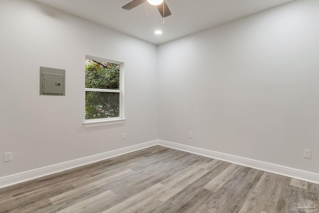 unfurnished room with ceiling fan, light hardwood / wood-style floors, and electric panel