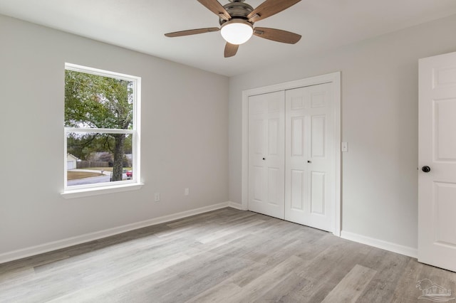 unfurnished bedroom with ceiling fan, light hardwood / wood-style flooring, and a closet