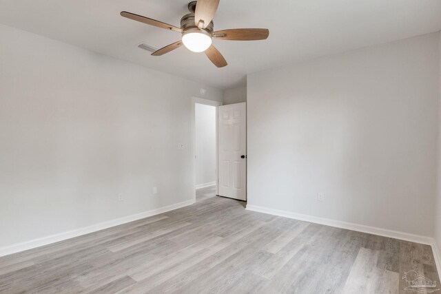 empty room with ceiling fan and light hardwood / wood-style flooring