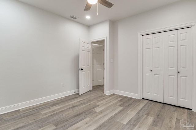 unfurnished bedroom featuring ceiling fan, light hardwood / wood-style floors, and a closet