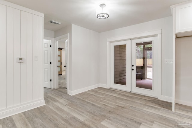 empty room with french doors and light wood-type flooring