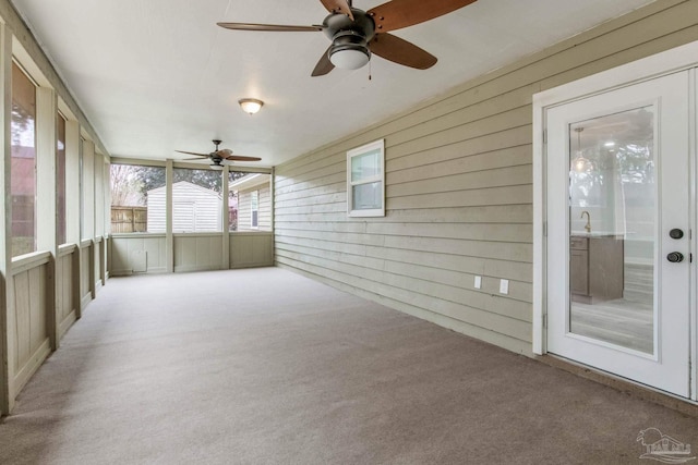 unfurnished sunroom with ceiling fan