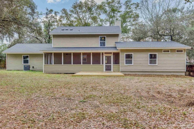 back of property with central AC, a yard, and a sunroom