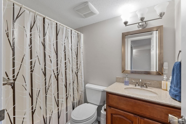 bathroom featuring visible vents, a shower with shower curtain, toilet, vanity, and a textured ceiling