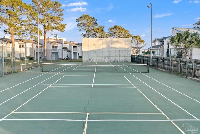 view of sport court with a residential view and fence