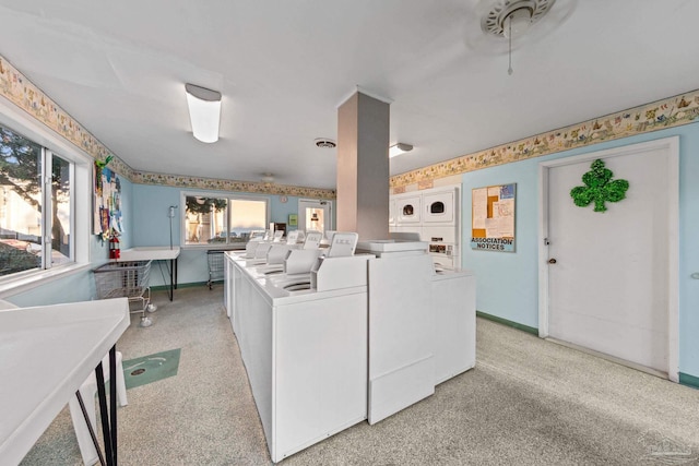 common laundry area with plenty of natural light, independent washer and dryer, light carpet, and baseboards