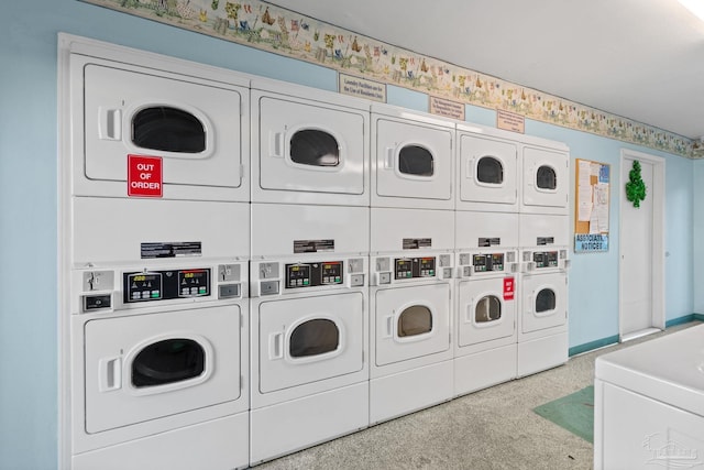 common laundry area with baseboards, stacked washing maching and dryer, and washer and dryer