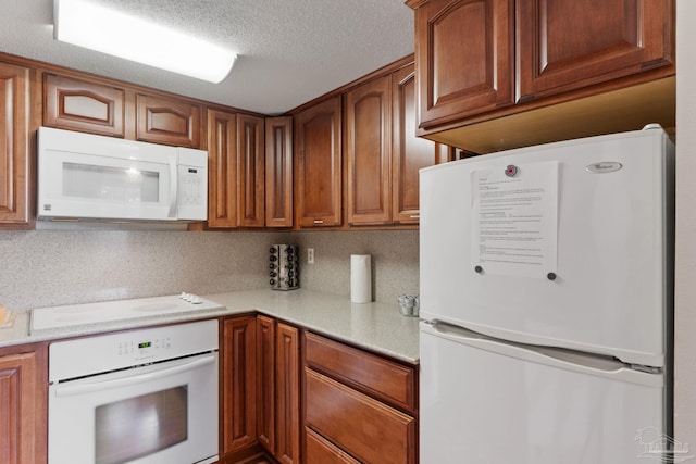 kitchen with a textured ceiling, white appliances, decorative backsplash, and brown cabinets