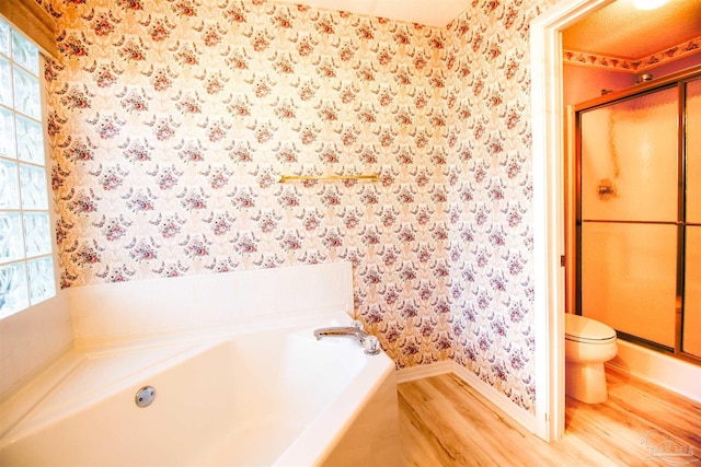 full bath with wallpapered walls, wood finished floors, baseboards, a garden tub, and a shower stall