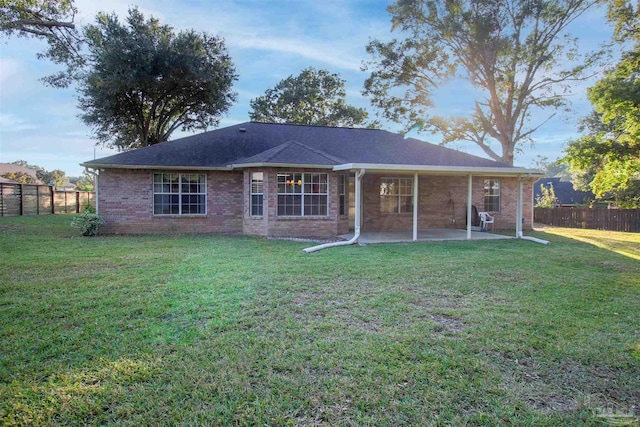 back of house with a patio area and a lawn