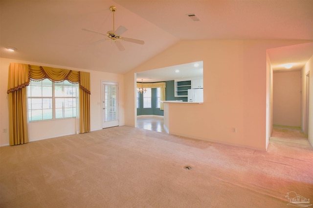 unfurnished living room with carpet, a ceiling fan, lofted ceiling, and a chandelier