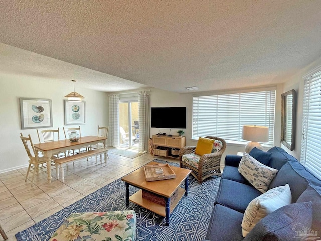 living room with a textured ceiling and light tile patterned flooring