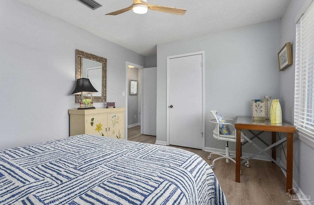 bedroom featuring a textured ceiling, hardwood / wood-style floors, and ceiling fan