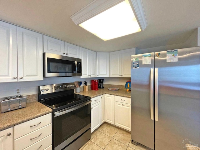 kitchen with stainless steel appliances, white cabinets, and light tile patterned floors