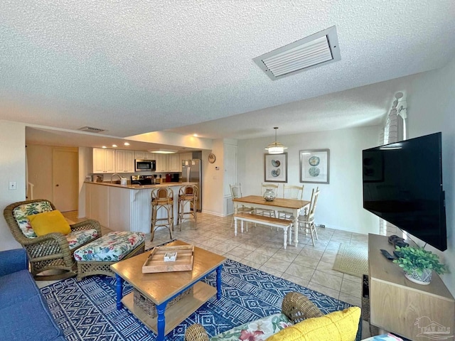 tiled living room featuring a textured ceiling