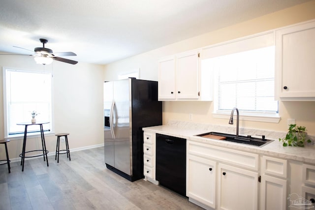 kitchen featuring black dishwasher, light wood-style flooring, white cabinets, a sink, and stainless steel fridge with ice dispenser