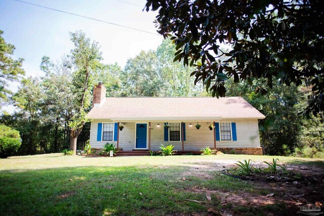 ranch-style home featuring covered porch and a front lawn