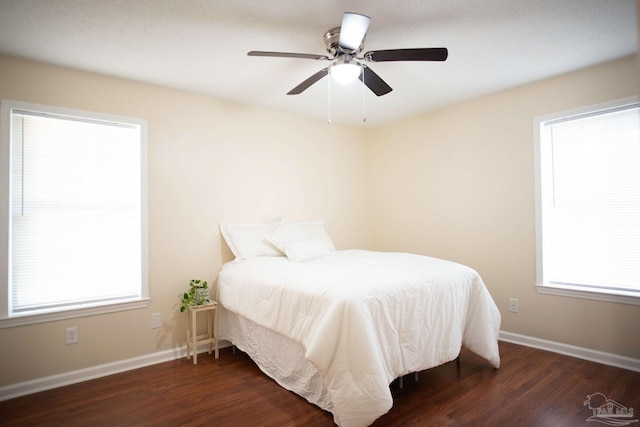 bedroom with dark wood-type flooring, ceiling fan, and baseboards