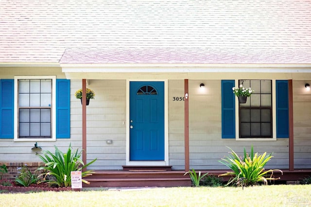 view of exterior entry with a shingled roof