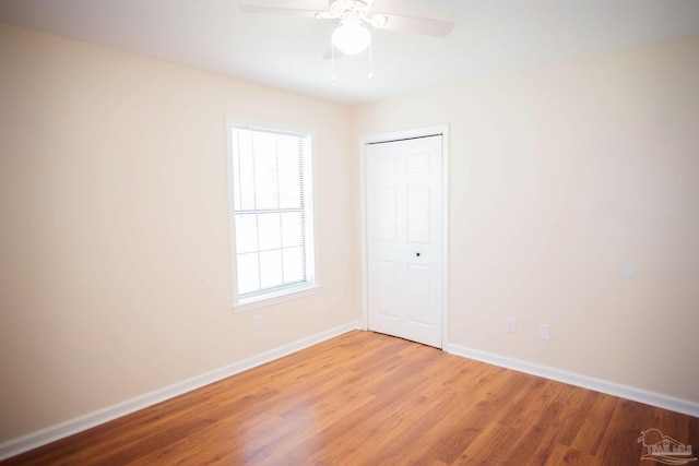 unfurnished room featuring light wood-type flooring, ceiling fan, and baseboards