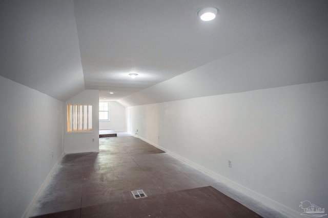 bonus room with vaulted ceiling, visible vents, and baseboards