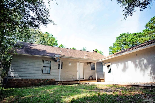 rear view of property with a yard