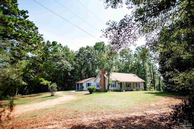 ranch-style home featuring driveway, a chimney, and a front yard