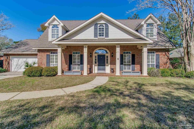 view of front of property with a porch, a front yard, and brick siding