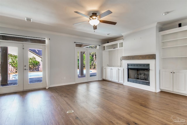 unfurnished living room with french doors, a fireplace, wood finished floors, and crown molding