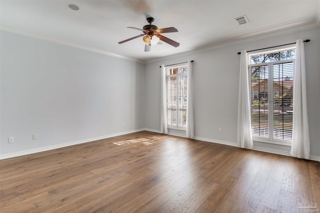 unfurnished room featuring a ceiling fan, crown molding, visible vents, and wood finished floors