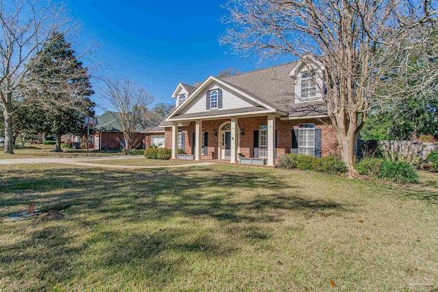 view of front facade featuring covered porch, brick siding, and a front lawn