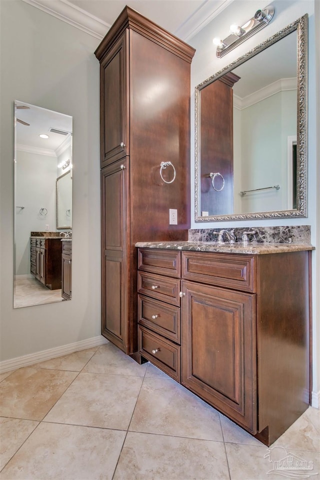 bathroom featuring tile patterned flooring, ornamental molding, baseboards, and vanity