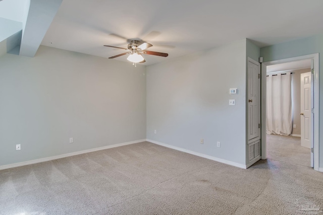 carpeted empty room featuring ceiling fan and baseboards