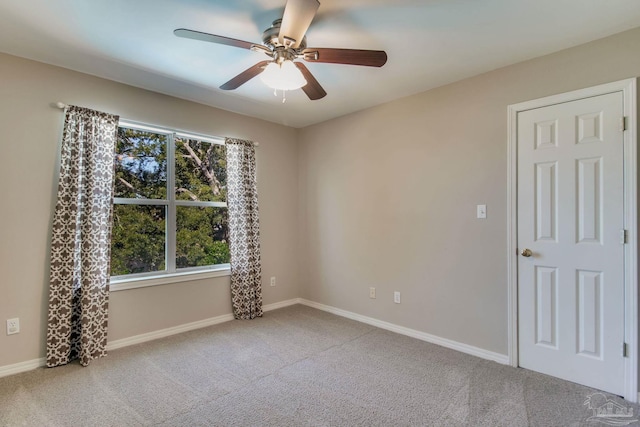 unfurnished room featuring carpet, baseboards, and a ceiling fan