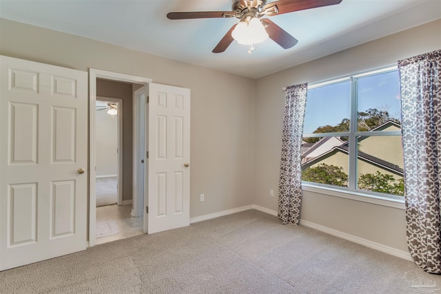 unfurnished bedroom featuring ceiling fan, baseboards, and carpet flooring