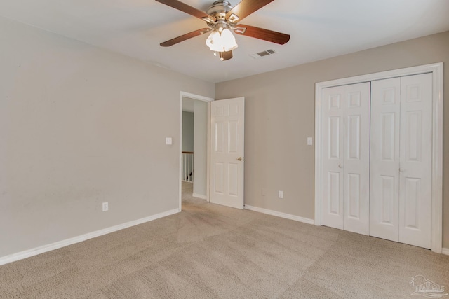 unfurnished bedroom with light colored carpet, a ceiling fan, baseboards, visible vents, and a closet