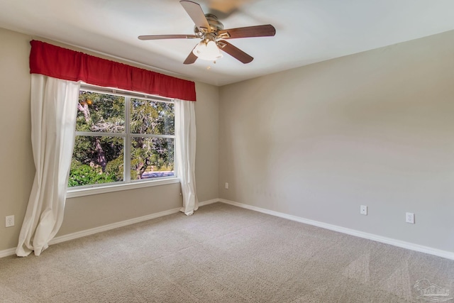 spare room with a ceiling fan, carpet, and baseboards