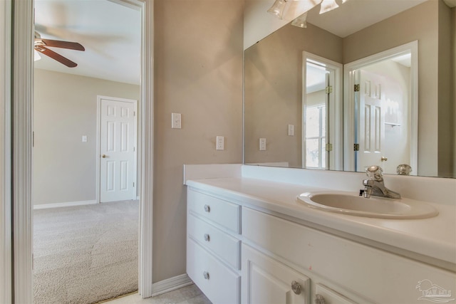 bathroom featuring baseboards, a ceiling fan, and vanity