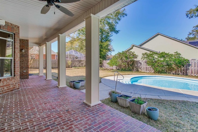 view of swimming pool with a fenced backyard, a fenced in pool, a ceiling fan, and a patio