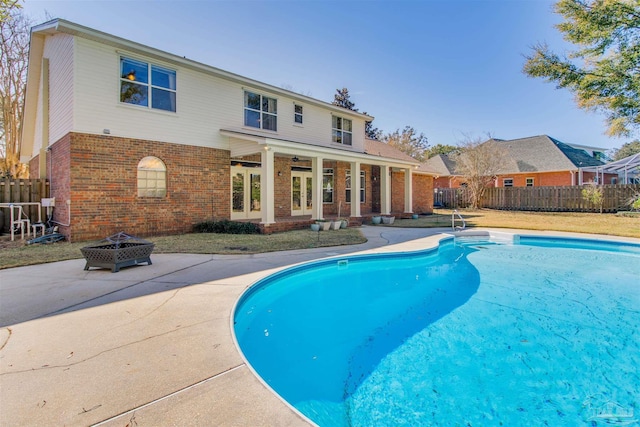 view of swimming pool featuring a fenced in pool, an outdoor fire pit, french doors, and fence