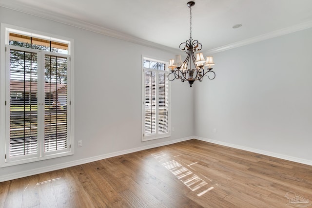 spare room with a healthy amount of sunlight, baseboards, crown molding, and hardwood / wood-style floors