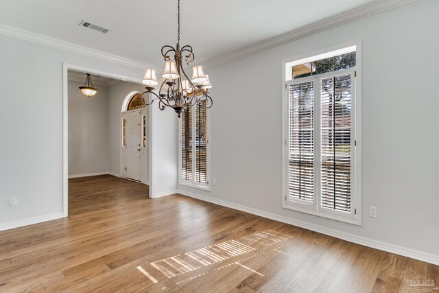 unfurnished dining area with plenty of natural light, light wood-type flooring, visible vents, and crown molding