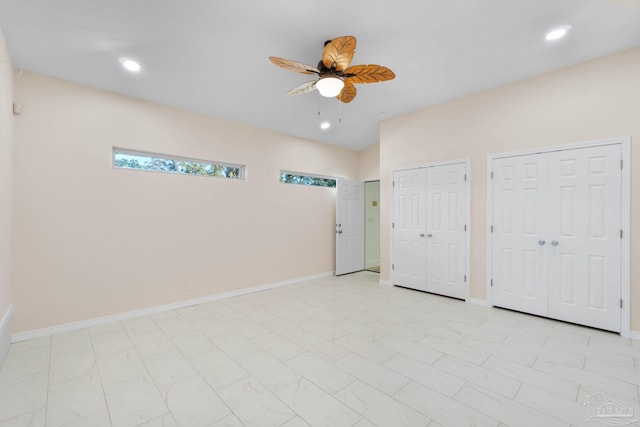 unfurnished bedroom with ceiling fan and two closets