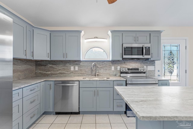 kitchen with light tile patterned flooring, stainless steel appliances, plenty of natural light, and sink