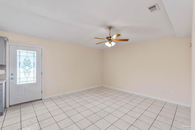 empty room with ceiling fan and light tile patterned flooring