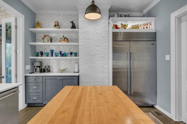 kitchen featuring wooden counters, gray cabinetry, stainless steel appliances, dark wood-type flooring, and decorative light fixtures